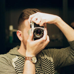 a self portait of me, kevin, holding a film camera toward a mirror